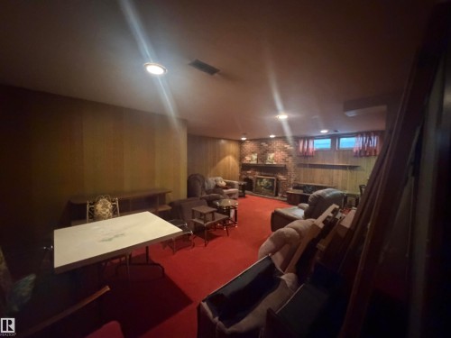 Recreation room featuring wood paneling, recessed lighting, red carpeting, and a brick fireplace - 13207 117 Street, Edmonton, AB 