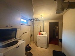 Utility space featuring a window, overhead cabinetry, and paneling - 