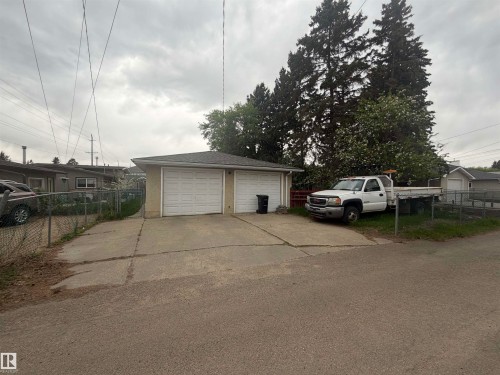 Detached two-stall garage with white panel doors and a concrete driveway - 13207 117 Street, Edmonton, AB 