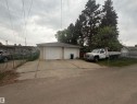 Detached two-stall garage with white panel doors and a concrete driveway - 13207 117 Street, Edmonton, AB 