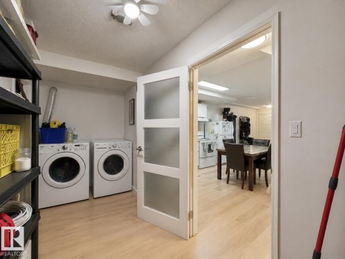 Dedicated laundry area with light wood-finish flooring, featuring a pair of front-loading appliances - #29 13580 38 St Nw, Edmonton, AB - Indoor Photo Showing Laundry Room