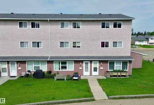 Multi-story stucco exterior featuring multiple windows and a shingled roof - #29 13580 38 St Nw, Edmonton, AB - Outdoor With Facade