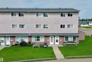 Multi-story stucco exterior featuring multiple windows and a shingled roof - #29 13580 38 St Nw, Edmonton, AB  - Outdoor With Facade 
