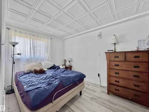 Bedroom featuring a decorative coffered ceiling and light wood-finish flooring - #29 13580 38 St Nw, Edmonton, AB - Indoor Photo Showing Bedroom