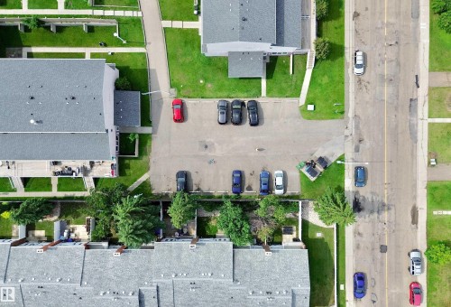 Aerial perspective showcasing multiple residential buildings with gray shingle roofing - #29 13580 38 St Nw, Edmonton, AB - 