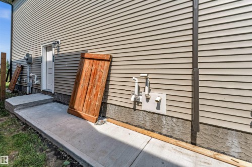 Exterior wall featuring light-colored horizontal siding and a concrete foundation - 1712 27 St Nw, Edmonton, AB - Outdoor With Exterior