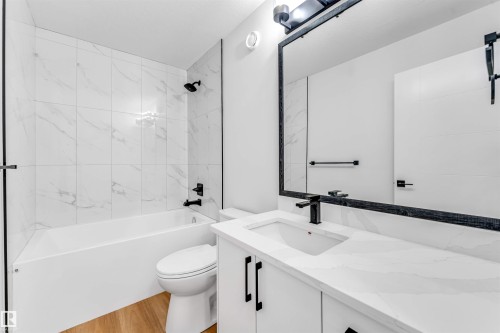 Bathroom featuring a white vanity with a rectangular sink, a white countertop, and matte black fixtures - 1714 27 St. Nw, Edmonton, AB - Indoor Photo Showing Bathroom