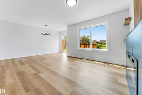 Open-concept living space with light wood-finish flooring - 1714 27 St. Nw, Edmonton, AB - Indoor