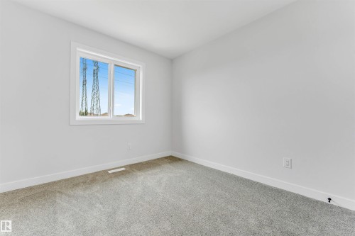 Clean interior room featuring light gray carpeting and white baseboards - 1714 27 St. Nw, Edmonton, AB - Indoor Photo Showing Other Room