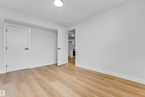 Spacious room featuring light wood-finish flooring, crisp white walls, and a recessed ceiling light - 1714 27 St. Nw, Edmonton, AB - Indoor Photo Showing Other Room