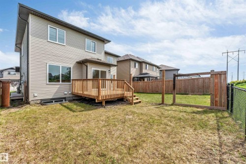 Rear exterior featuring a wooden deck with railing, siding facade, and multiple windows - 1714 27 St. Nw, Edmonton, AB - Outdoor With Exterior