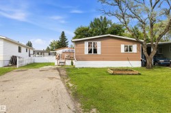 Front exterior with brown siding, white trim, and white window shutters - 