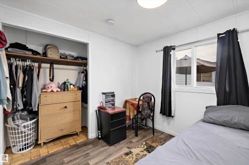 Room featuring wood-finish flooring, a double window with black drapery rods, and a ceiling-mounted light fixture - 46 Maple Terrace Northwest, Edmonton, AB - Indoor Photo Showing Bedroom