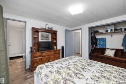 Room featuring wood-finish flooring, a flush-mount ceiling light, and an open closet - 