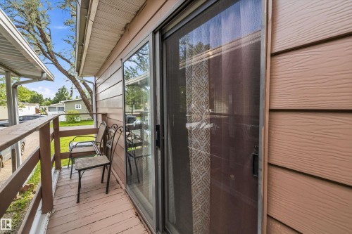 Exterior sliding glass door opening to a private wooden side deck with a matching wood railing - 46 Maple Terrace Northwest, Edmonton, AB - Outdoor With Deck Patio Veranda With Exterior