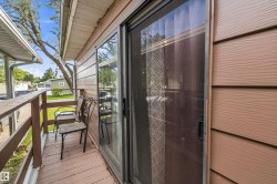 Exterior sliding glass door opening to a private wooden side deck with a matching wood railing - 