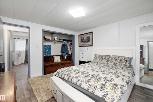 Spacious primary bedroom featuring wood-finish flooring, white paneled walls, and a recessed ceiling light - 46 Maple Terrace Northwest, Edmonton, AB - Indoor Photo Showing Bedroom