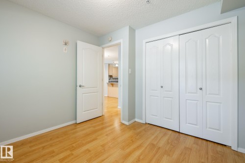 Room featuring wood-finish flooring, light gray wall paint, and white trim - #103 12838 65 St Nw Nw, Edmonton, AB - Indoor Photo Showing Other Room