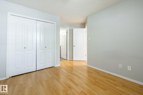 Room featuring wood-finish flooring, light grey walls, and white trim - #103 12838 65 St Nw Nw, Edmonton, AB - Indoor Photo Showing Other Room
