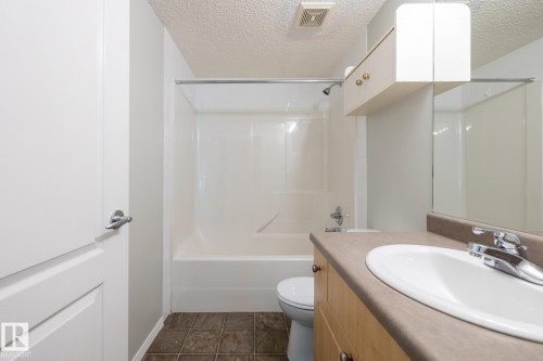 Bathroom with a white tub and shower combination featuring a chrome fixture - #103 12838 65 St Nw Nw, Edmonton, AB - Indoor Photo Showing Bathroom