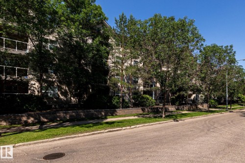 Low-rise building exterior featuring a stone facade and multiple private balconies with white railings - #103 12838 65 St Nw Nw, Edmonton, AB - Outdoor