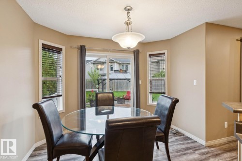 Dining area with wood-finish flooring and a contemporary ceiling light fixture - 16765 119 Street Nw, Edmonton, AB - Indoor Photo Showing Dining Room