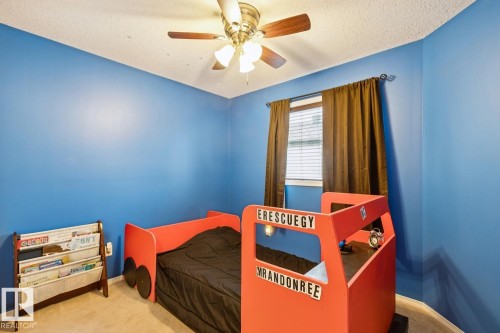 Bedroom featuring a ceiling fan with light fixture, window with blinds and dark-toned curtains, and carpeted flooring - 16765 119 Street Nw, Edmonton, AB - Indoor Photo Showing Bedroom