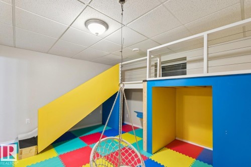 Recreational space featuring a built-in play structure with a slide, an elevated platform, and an integrated cubby - 16765 119 Street Nw, Edmonton, AB - Indoor Photo Showing Other Room