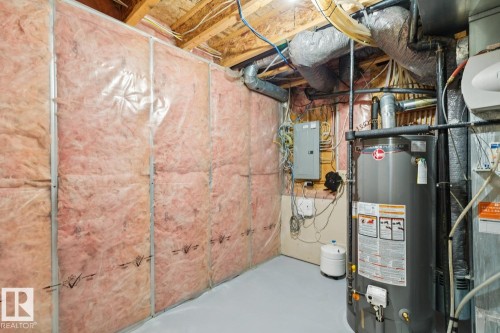 Utility room featuring a water heater, electrical panel, exposed ductwork, insulated walls, and a painted concrete floor - 16765 119 Street Nw, Edmonton, AB - Indoor Photo Showing Basement