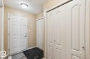 Entryway featuring a paneled door, wood-finish flooring, and multiple bi-fold storage closets - 16765 119 Street Nw, Edmonton, AB  - Indoor Photo Showing Other Room 