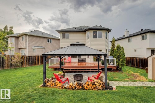Spacious backyard featuring a covered gazebo, fire pit area with stone paving, wood deck, and a manicured lawn - 16765 119 Street Nw, Edmonton, AB - Outdoor With Deck Patio Veranda With Exterior