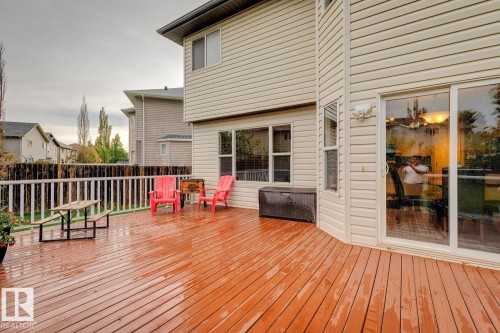 Spacious outdoor deck featuring wood-finish flooring, white railing, and sliding glass door access to the interior - 16765 119 Street Nw, Edmonton, AB - Outdoor With Deck Patio Veranda With Exterior