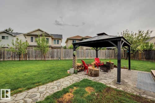 Spacious backyard featuring an expansive lawn, a stone pathway, and a covered gazebo with a flagstone patio - 16765 119 Street Nw, Edmonton, AB - Outdoor With Backyard