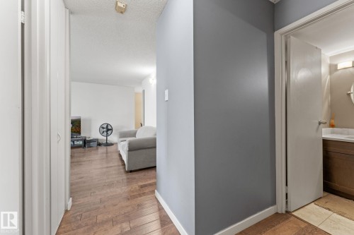 Wood-finish flooring throughout, complemented by light gray and white wall paint - #503 10175 114 St Nw, Edmonton, AB - Indoor Photo Showing Other Room