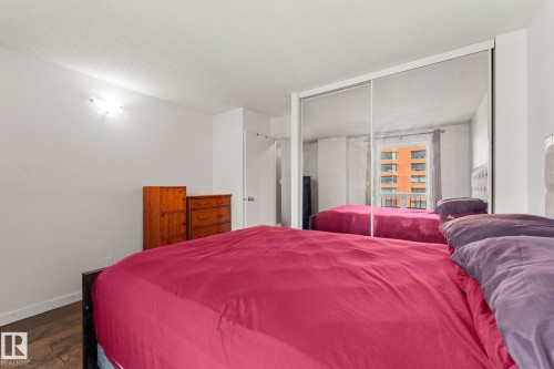 Mirrored closet doors providing visual expansion - #503 10175 114 St Nw, Edmonton, AB - Indoor Photo Showing Bedroom