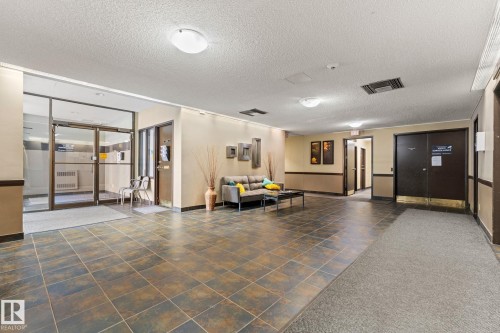 Spacious common area featuring durable tile flooring, recessed lighting, and wall-mounted art installations - #503 10175 114 St Nw, Edmonton, AB - Indoor Photo Showing Other Room