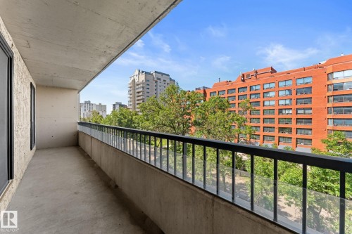 Private balcony featuring concrete flooring, a black metal railing, and clear glass panels - #503 10175 114 St Nw, Edmonton, AB - Outdoor With Balcony With Exterior