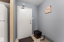 Entryway featuring a white solid door with a deadbolt and peephole, light gray wall paint, and cream-toned tiled flooring - #503 10175 114 St Nw, Edmonton, AB  - Indoor Photo Showing Other Room 