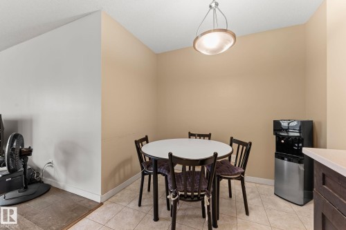 Dining area featuring neutral-toned walls, tile flooring, and a contemporary pendant light fixture - #503 10175 114 St Nw, Edmonton, AB - Indoor Photo Showing Dining Room