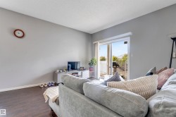 Sliding glass patio door with white trim, dark wood-finish flooring, light gray wall paint, and white baseboards - 