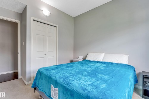 Neutral tone walls complemented by carpet flooring - #102 3040 Spence Wd Sw, Edmonton, AB - Indoor Photo Showing Bedroom