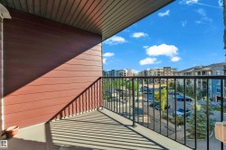 Private balcony featuring a concrete floor, dark brown horizontal siding, and a black metal railing - 