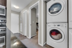 Dedicated laundry area featuring a white stacked washer and dryer unit - 