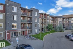 Multi-story residential building featuring dark stacked stone and red siding accents - 