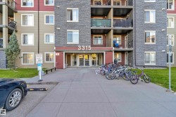 Multi-story building entrance featuring glass doors, exterior stone veneer, and multiple balconies - 
