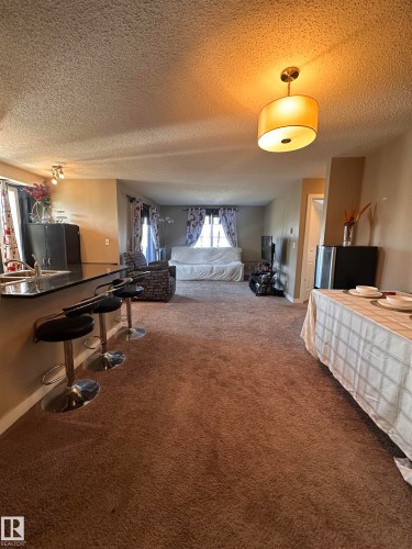 Open-concept living space featuring brown carpet flooring - #419 11808 22 Av Sw, Edmonton, AB - Indoor