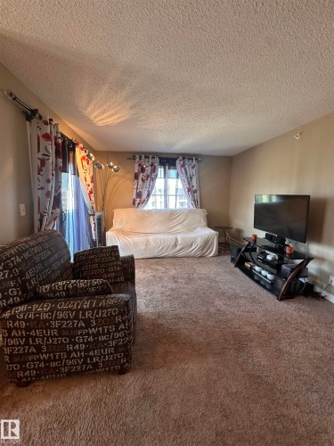 Carpeted living area featuring neutral wall tones - #419 11808 22 Av Sw, Edmonton, AB - Indoor