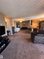 Expansive interior with textured ceilings and brown carpeting throughout - 