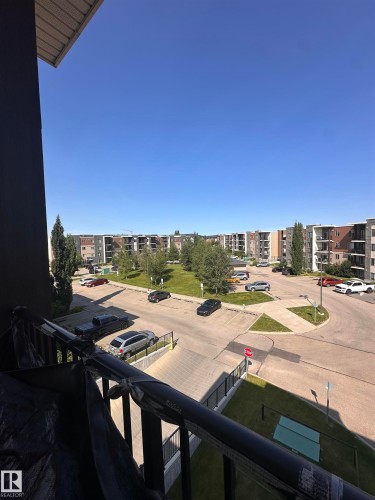 Expansive exterior grounds featuring landscaped green spaces and paved parking areas - #419 11808 22 Av Sw, Edmonton, AB - Outdoor With View