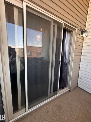 Sliding glass door with white frame and screen - #419 11808 22 Av Sw, Edmonton, AB - Outdoor With Exterior